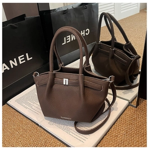 Détail du sac à main en cuir grainé marron foncé avec fermoir argenté et bandoulière