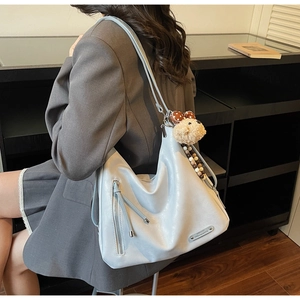 Detail view of large light blue PU leather tote bag with silver zipper and bear charm