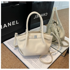 Détail du cuir grainé crème et de la boucle métallique argentée de ce sac élégant