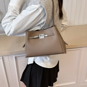 Detail of khaki leather handbag featuring lychee texture and silver metal twist lock buckle