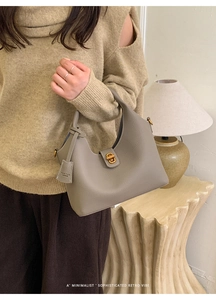 Detail der taupefarbenen Eimer-Tasche aus Leder mit goldenem Drehverschluss