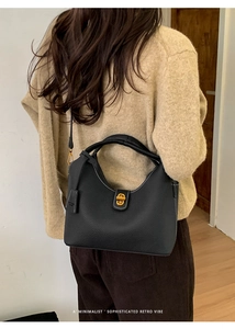 Detail der schwarzen Leder-Beuteltasche mit weißen Kontrastnähten an einem Modell