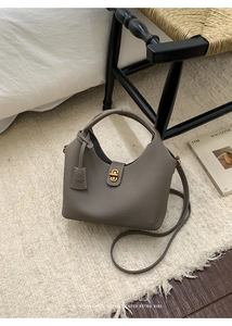 Detail der grauen Korb-Tasche aus genarbtem Leder mit goldenem Drehverschluss