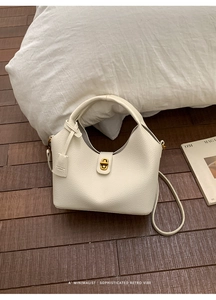 Detailansicht der weißen Handtasche aus Kieselleder mit hochwertigem goldenem Drehverschluss