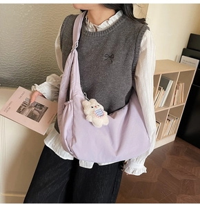 Purple crescent crossbody bag with wide strap and white rabbit plush pendant detail