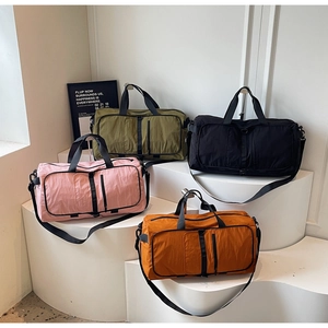 Foldable fitness travel bags in pink, green, black and orange on display stands
