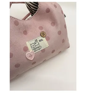 Détail du sac rose à pois avec broderie chat et boutons de style vintage