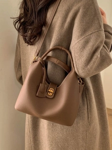 Elegante Beuteltasche aus braunem Leder mit goldenem Schloss für herbstliche Outfits