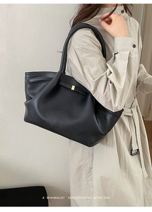 Λεπτομέρεια από μαύρη δερμάτινη τσάντα tote με vintage χρυσή μεταλλική αγκράφα