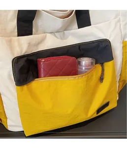 Internal view of large color-block tote bag showing spacious storage for wallet and makeup