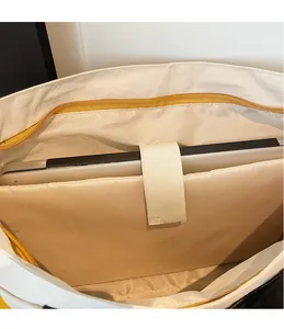 Detail view of the interior laptop compartment with velcro strap and smooth yellow zipper