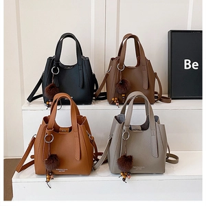 Sacs à bandoulière motif litchi en quatre couleurs avec pendentif perle sur des marches