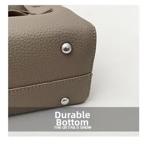 Détail du fond du sac en cuir grainé gris éléphant avec clous de protection en métal argenté