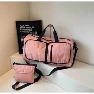 Pink large travel duffel bag and matching crossbody set on white display steps