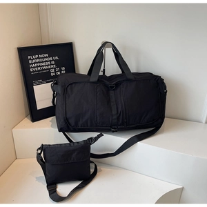 Detail shot of black foldable travel bag set with large tote and matching crossbody bag