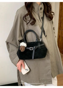 Detail einer Vintage-Wildledertasche mit Lederriemen und Plüsch-Handschuh-Anhänger