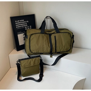 Olive green travel bag and small messenger bag set with black straps on a white display
