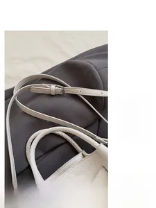 Détail du sac seau en cuir grainé blanc avec bandoulière réglable et poignée chic