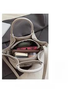 Vue de dessus de l'intérieur du sac seau beige montrant les compartiments de rangement