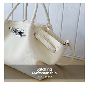 Detailed close-up of cream lychee grain leather handbag with silver metallic twist lock