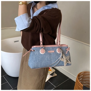 Dettaglio della borsa bowling in denim con finiture rosa e ciondolo a stella argento
