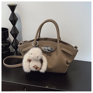 Detail of brown litchi leather bucket bag with silver twist lock and bunny charm