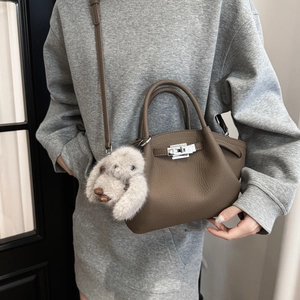 Brown lychee leather shoulder bucket bag with plush bunny charm and metal buckle
