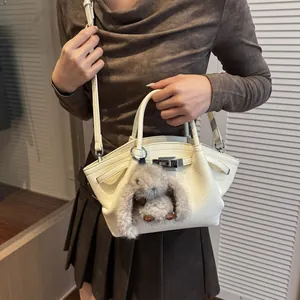 Detailed close-up of cream leather bucket bag texture with plush rabbit charm detail