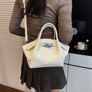 Minimalist ivory lychee leather bucket bag with silver twist lock and wing-shaped design