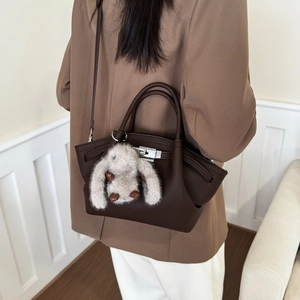 Brown litchi grain leather bucket bag with silver clasp and cute white rabbit plush charm