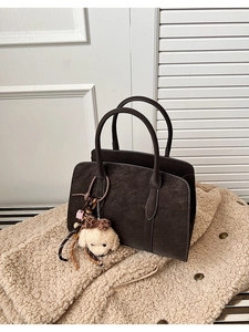 Détail du grand sac cabas vintage marron avec peluche chien sur manteau en fausse fourrure