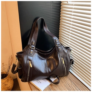 Detailed close-up of dark brown vintage tote bag with gold zippers and oil wax leather texture
