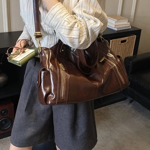 Detailed view of dark brown vintage tote bag with gold zippers and adjustable strap