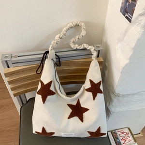 Detail of white canvas tote bag featuring brown plush stars and a ruched cloud shoulder strap