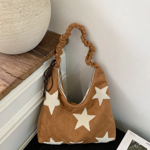 Detail of caramel suede tote bag with white plush stars and ruched scrunchie handle