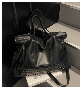 Detailansicht der schwarzen PU-Leder-Tasche mit silbernen Nieten und langer Quaste