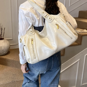 Detail of off-white vintage tote bag showing soft leather texture and side zipper
