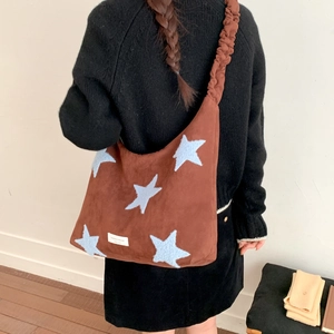 Detailed view of brown velvet star pattern hobo bag with ruffled shoulder strap