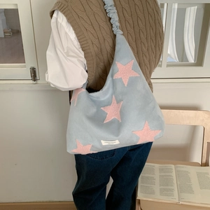 Detail of light blue star tote bag with ruched shoulder strap and pink star pattern