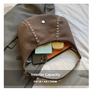 Dettaglio dell'interno capiente della borsa in pelle scamosciata marrone con cellulare
