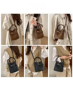 Détail des sacs seaux en cuir grainé marron et noir avec boucles métalliques et bandoulière