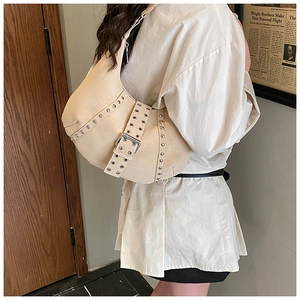 Dettaglio borsa hobo beige con borchie argentate e tracolla in stile retrò vintage
