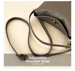 Detail showing the adjustable leather shoulder strap and matte gold metal hardware buckle