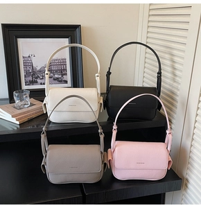 Detail view of four textured leather handbags in white, black, gray, and pink colors