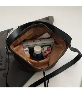 Vue de dessus montrant l'intérieur spacieux du sac seau marron avec accessoires