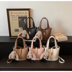 Colección de bolsos cubo con textura de lichi en varios colores y colgantes de conejo
