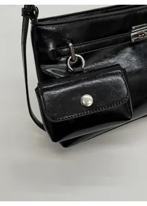 Dettaglio della borsa a spalla in pelle nera lucida con un mini borsellino portamonete fisso