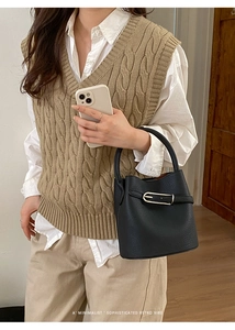 Sac seau en cuir noir chic avec boucle métallique porté avec une tenue tendance