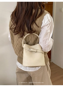 Détail du sac seau beige avec texture cuir grainé et boucle en métal argenté