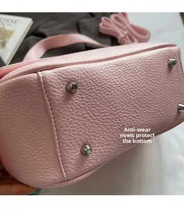 Detail of pink lychee leather bag bottom with four silver protective metal rivets